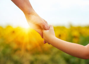 child and parent holding hands